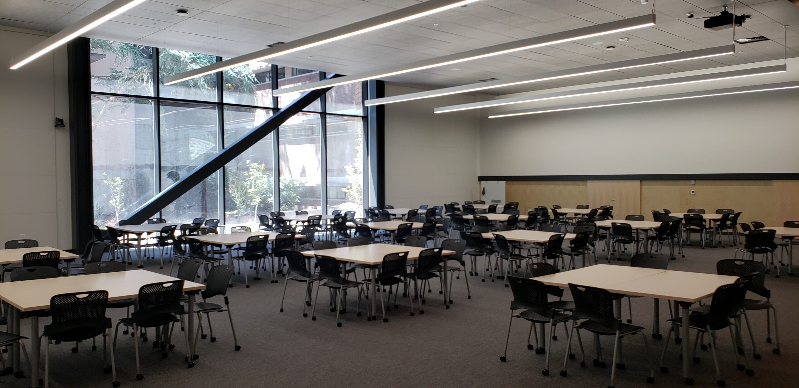 A photo of the HSEB 101 classroom taken from the front right corner, showing the pod style seating.