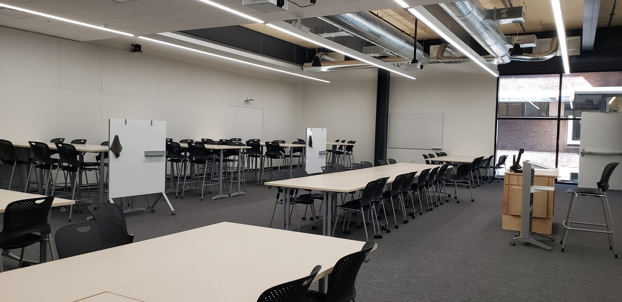 A photo of the HSEB 125 classroom taken from the front right corner, showing the pod style seating.