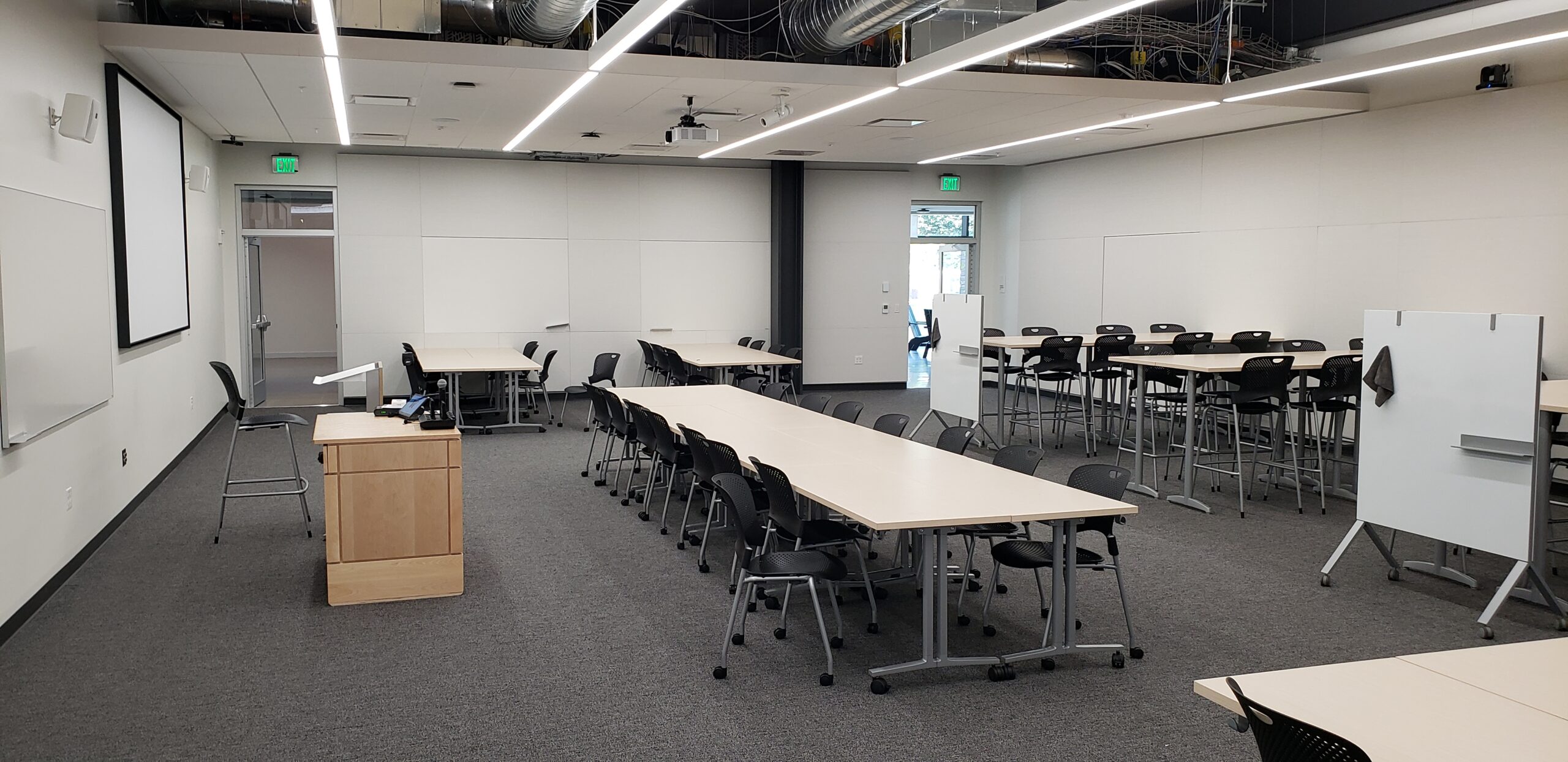 A photo of the HSEB 125 classroom taken from the front left corner, showing the pod style seating.