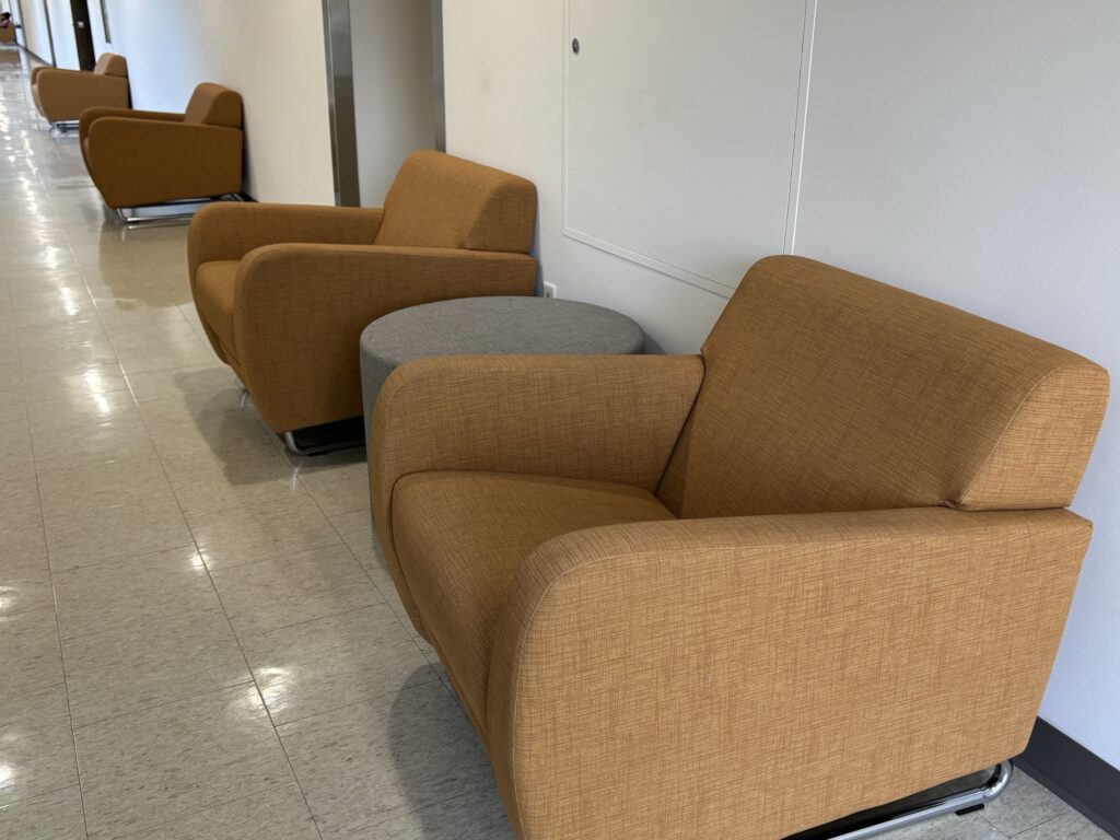 Lounge chairs and ottomans line the hallway of the Health Science Building T-wing north corridor.