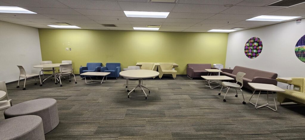 An open space with lounge chairs and tables for group study on the Health Science Building fourth floor.