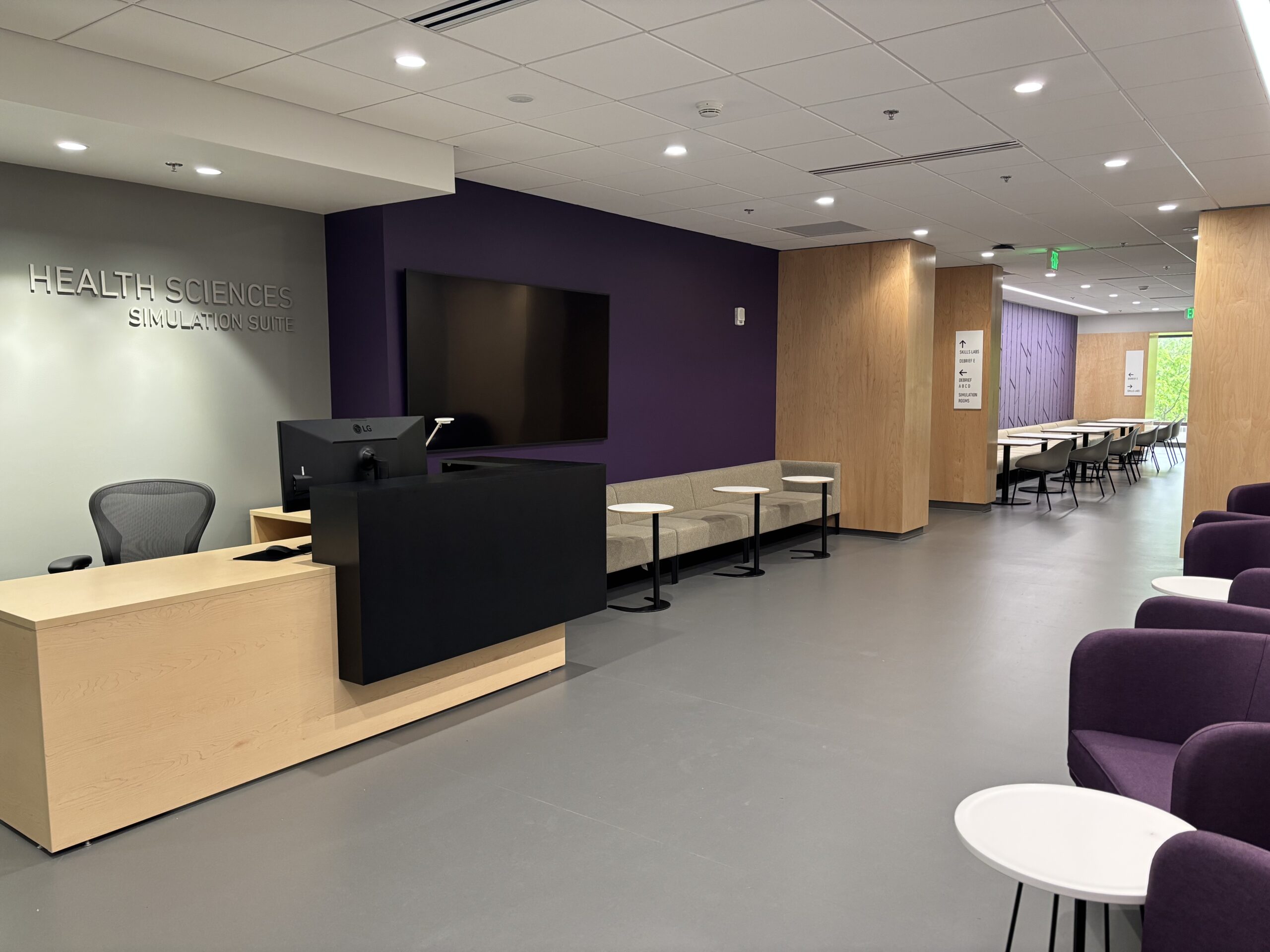 Photo of the front waiting room of the T672-98 Simulation Suite, showing the front desk area and bench seating.